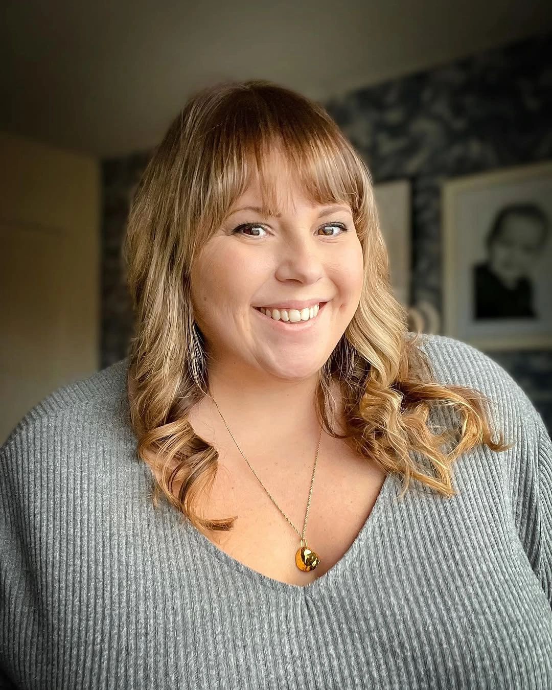 Full bangs with blonde wavy shoulder-length hair