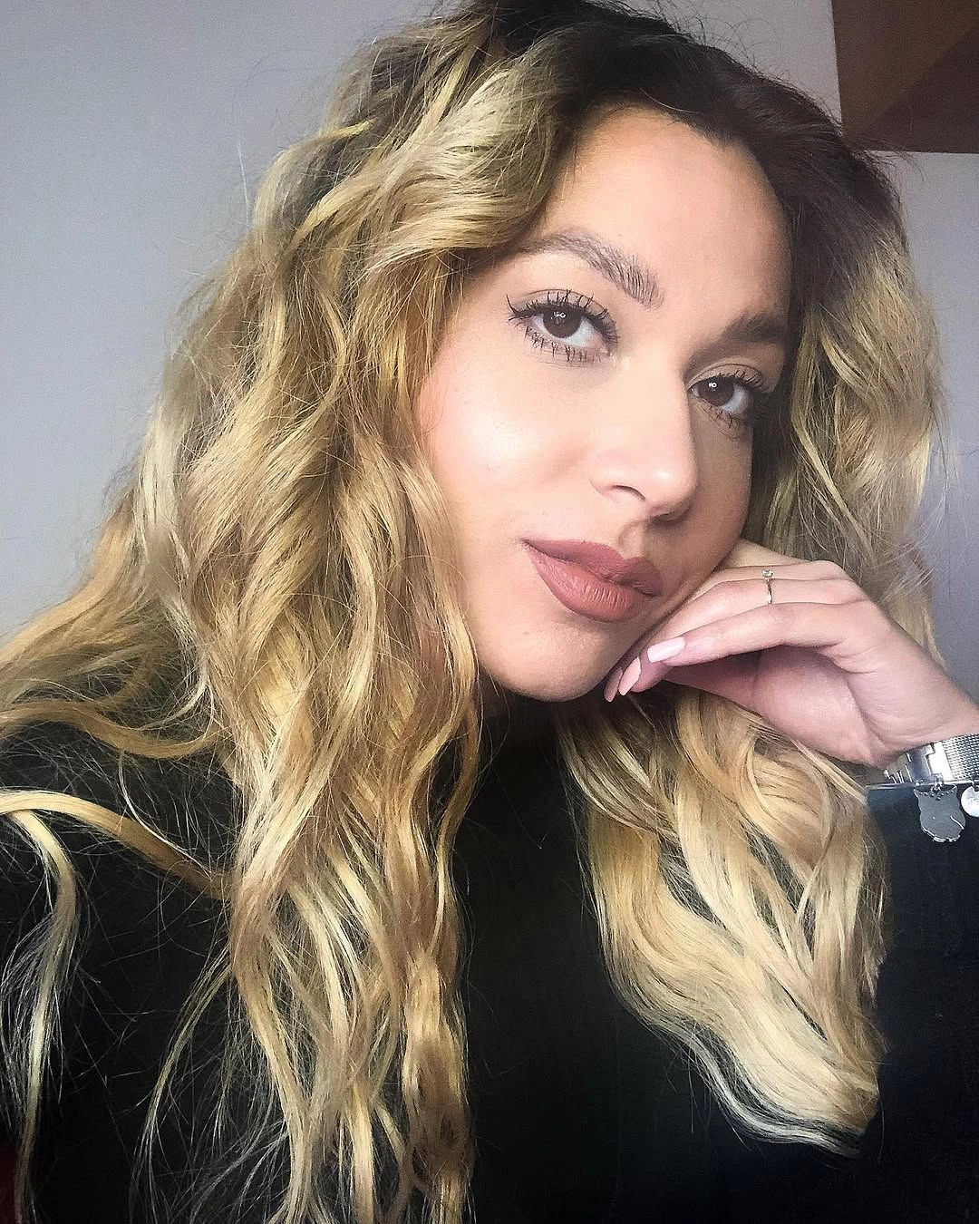 Long blonde waves with darker roots and loose texture