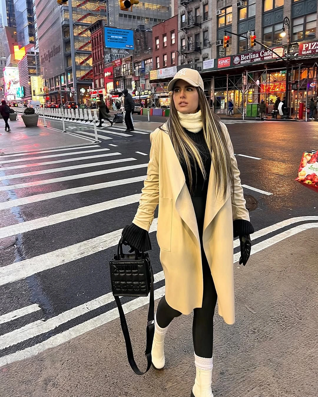 Woman in cream coat and light boots on city crosswalk