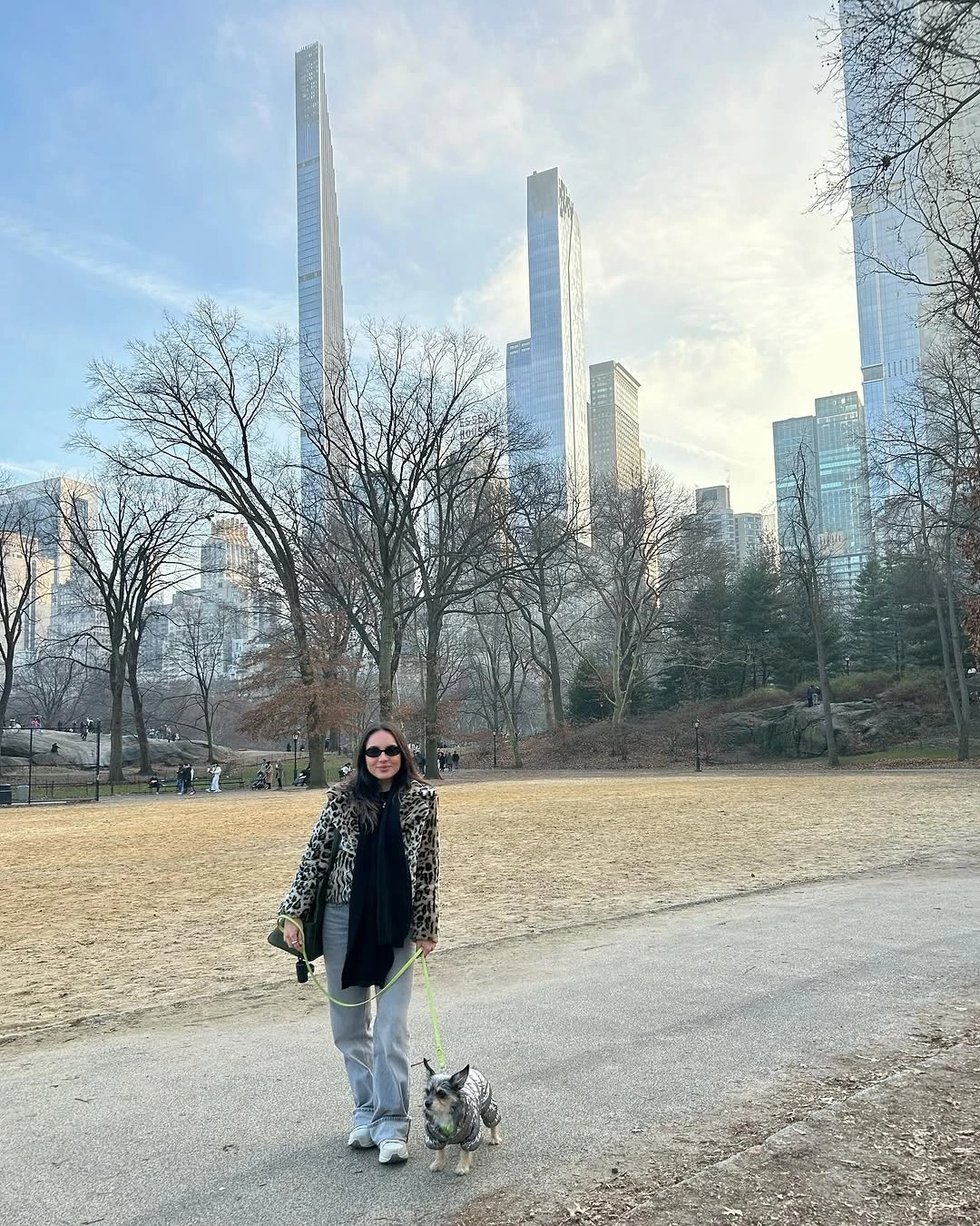 Woman in patterned jacket, loose jeans, and white sneakers