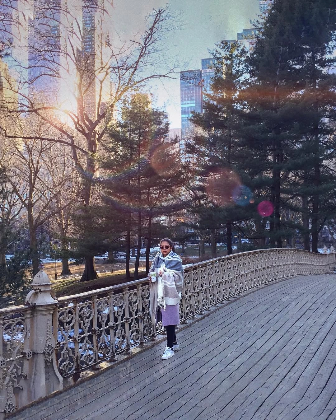 Woman in pale outerwear with scarf, leggings, and white sneakers