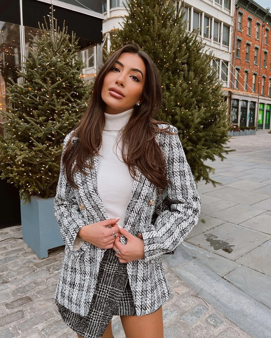 Woman in patterned blazer with white top and short dark hem