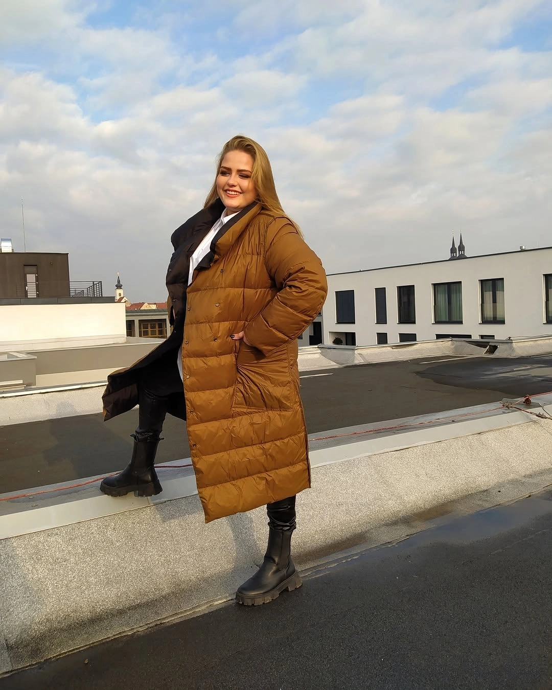 Long brown puffer coat with white top and black boots