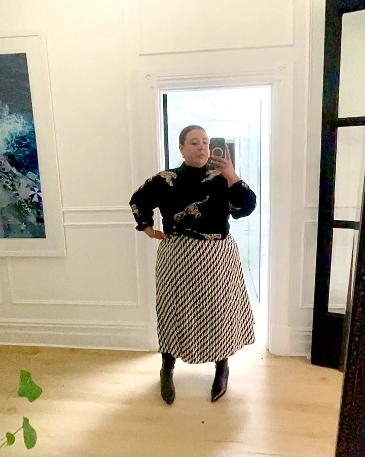 Black sweater with patterned long skirt and ankle boots