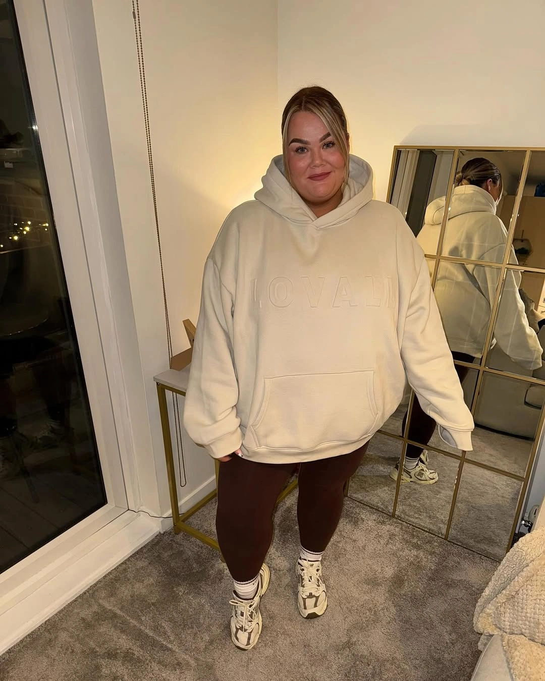 Oversized cream hoodie with brown leggings and sneakers