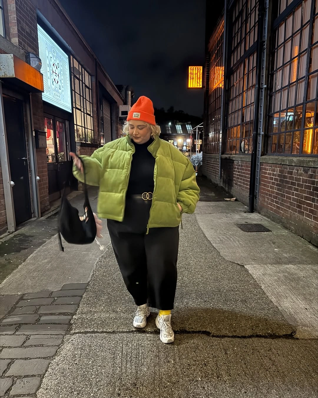 Light green puffer jacket with orange beanie and black outfit