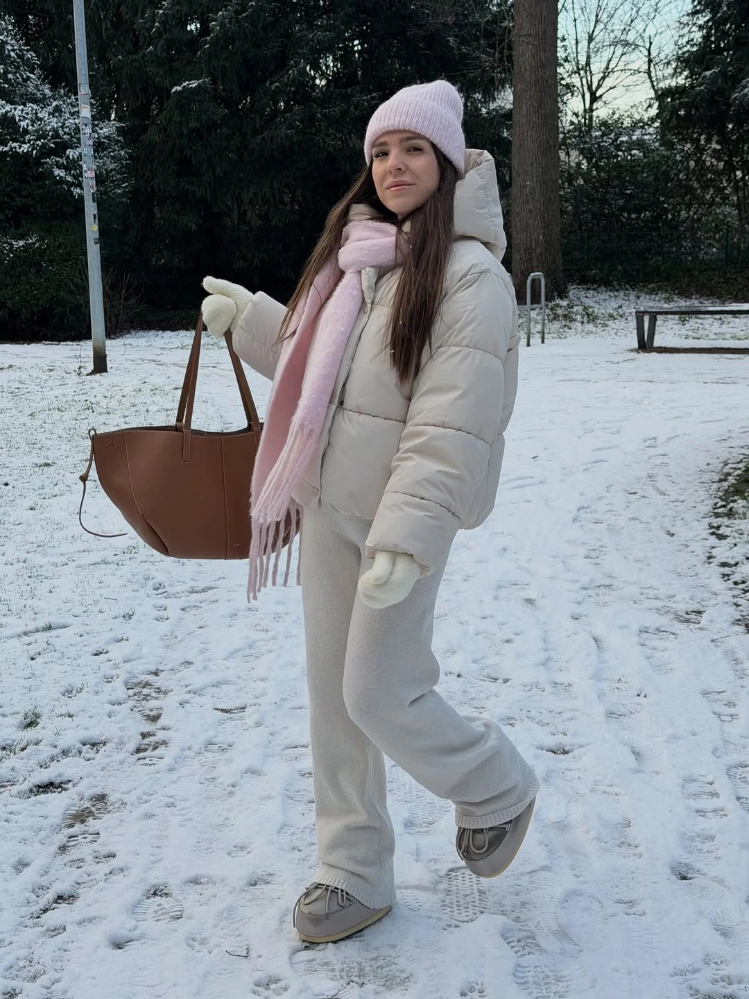 white puffer with ivory trousers pale pink scarf brown tote and gray sneakers