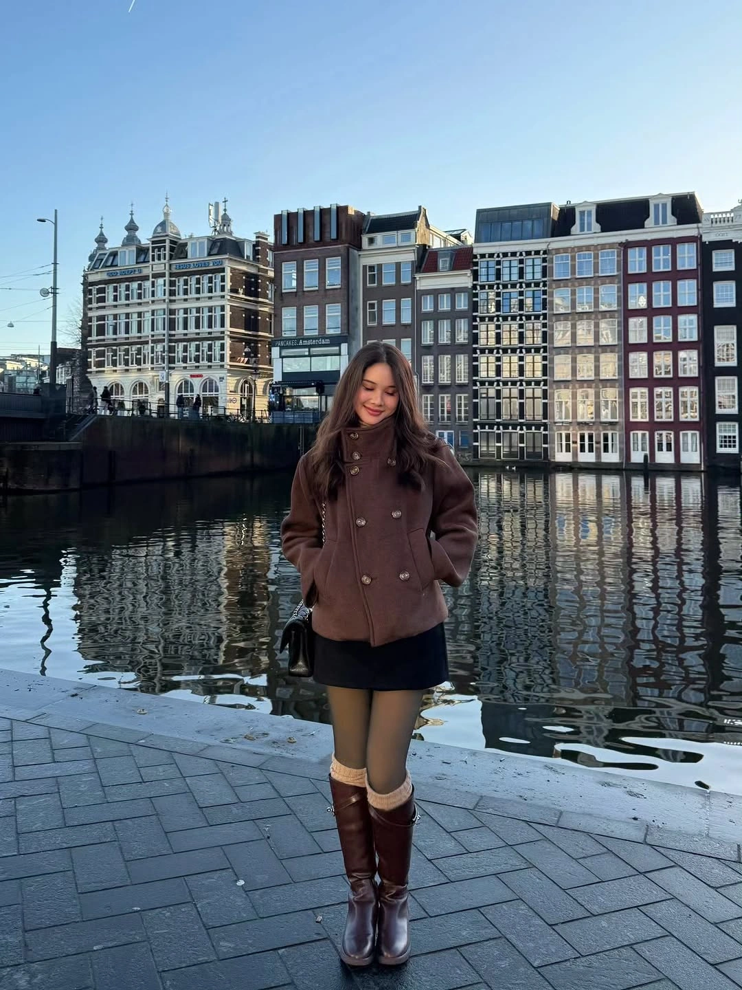 burgundy buttoned jacket with black skirt tights and tall brown boots