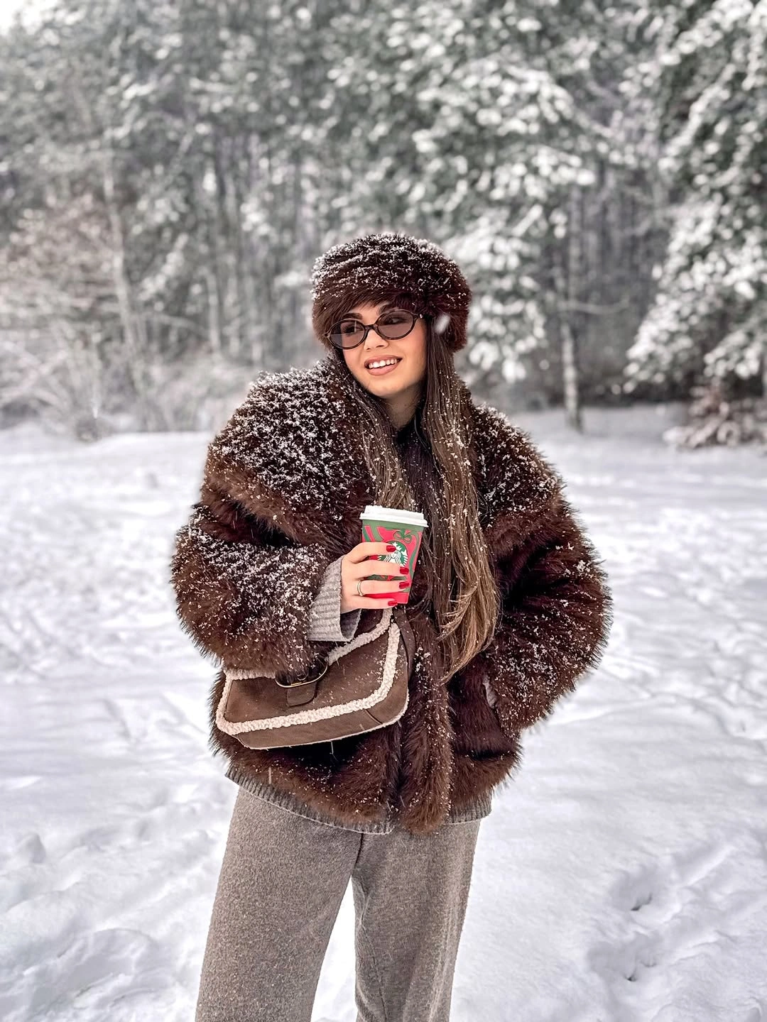 dark brown textured coat with gray trousers brown hat and shoulder bag