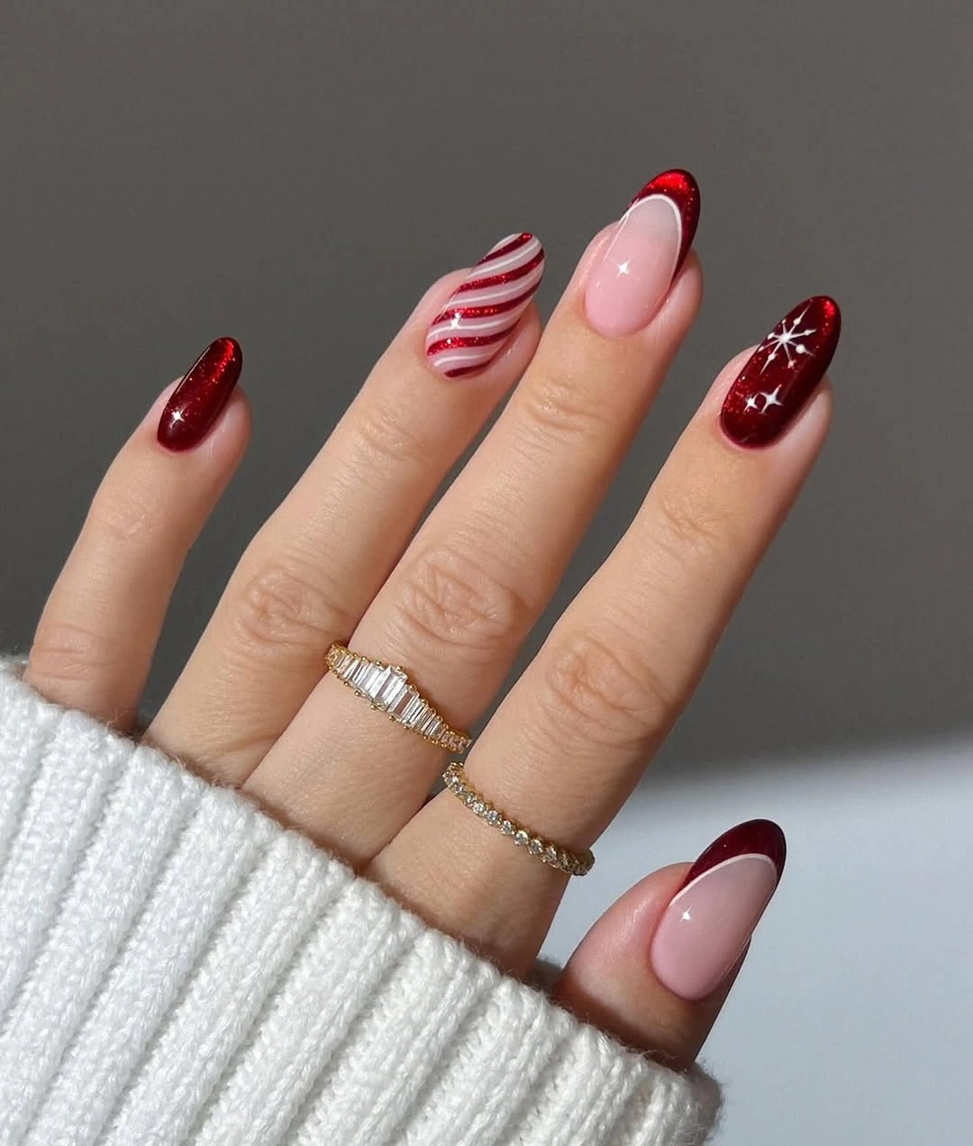 Short almond nails with burgundy tips, stripes, and starbursts