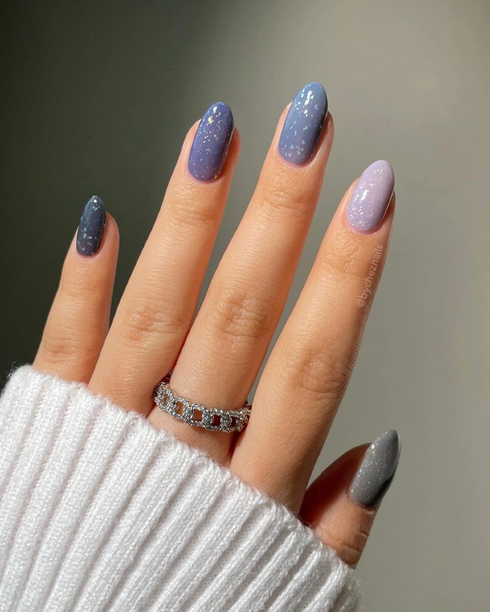 Short cool-toned oval nails with tiny pale speckles