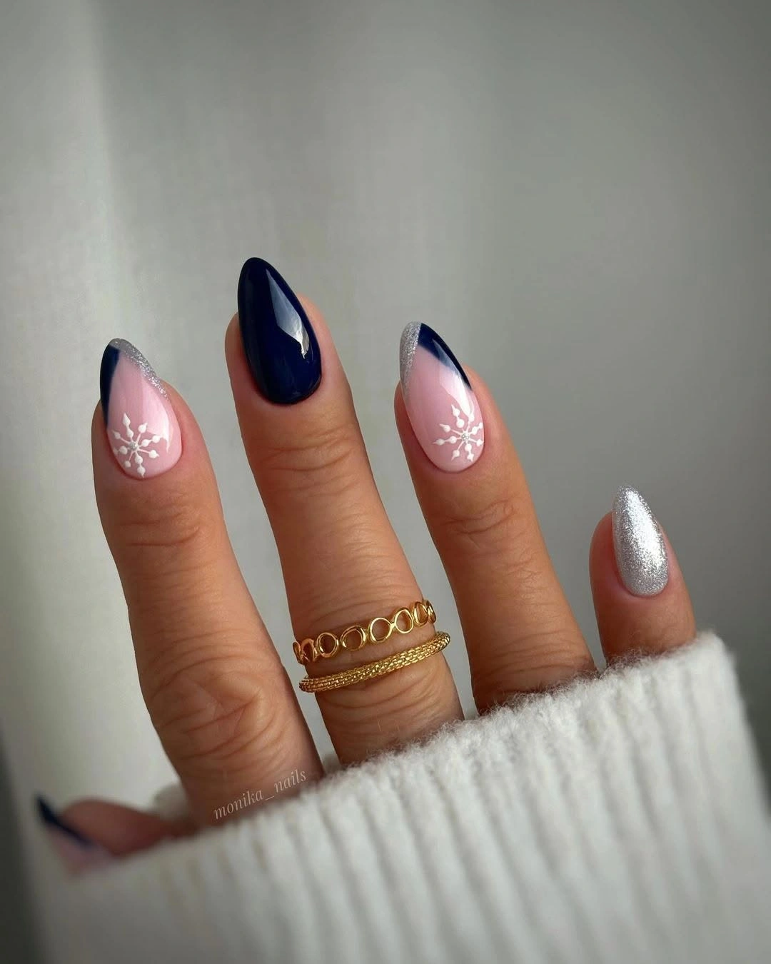 Short almond nails with navy tips, silver glitter, and snowflakes