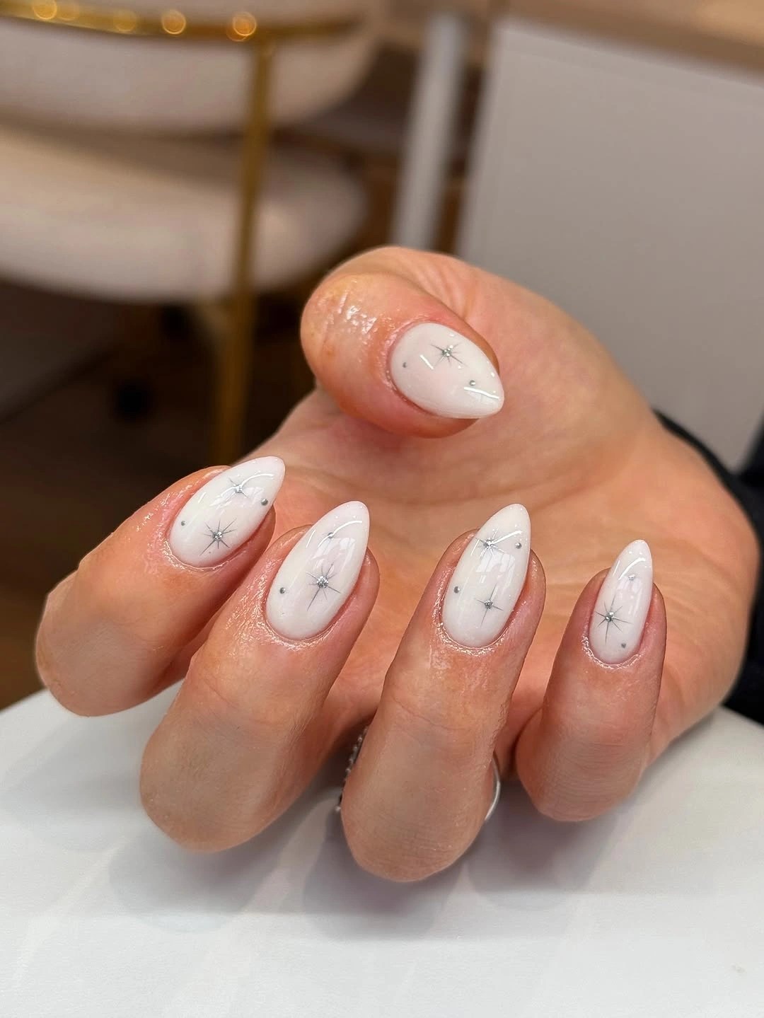 Milky white short almond nails with silver starburst lines