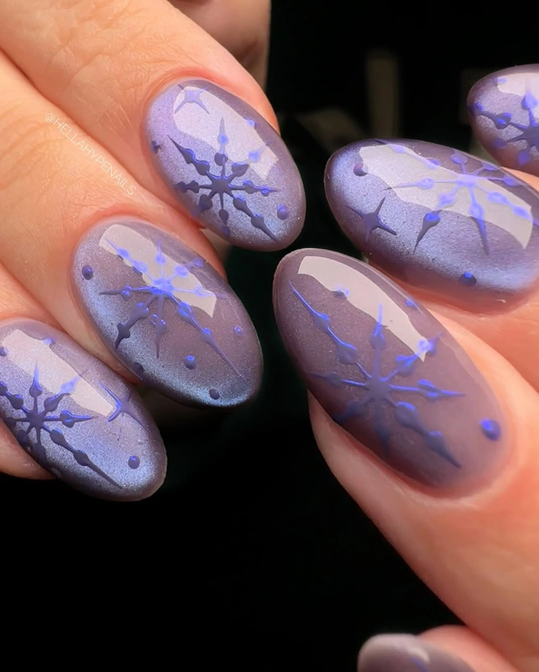 Short lavender-gray almond nails with blue branching snowflake marks