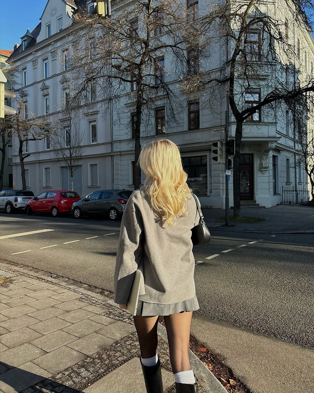 Relaxed ivory sweater with black A-line midi skirt and chunky boots