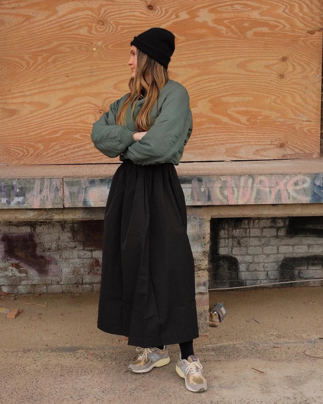 Tan jacket with short black skirt and tall brown boots