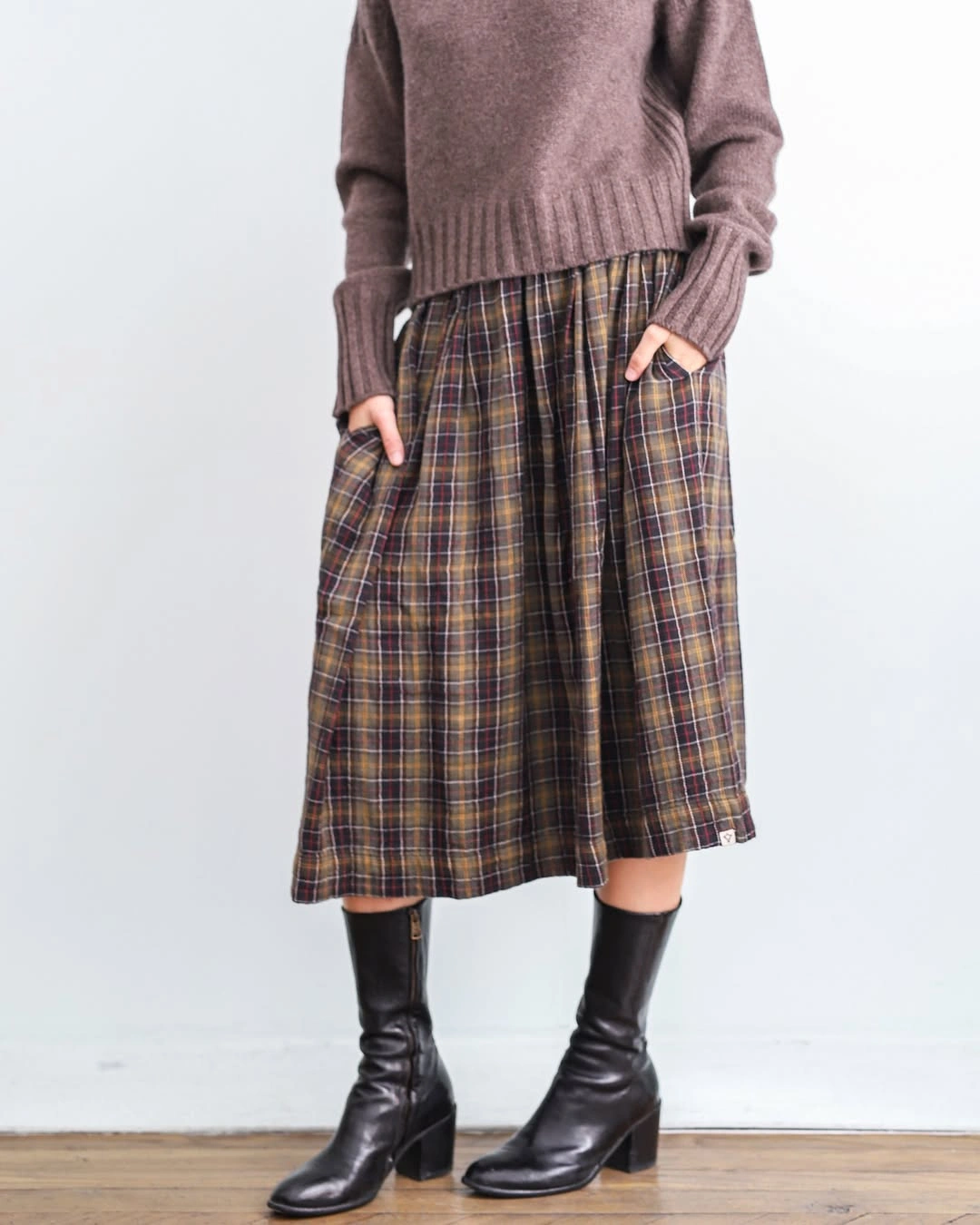 Beige fitted top with voluminous plaid maxi skirt and brown boots